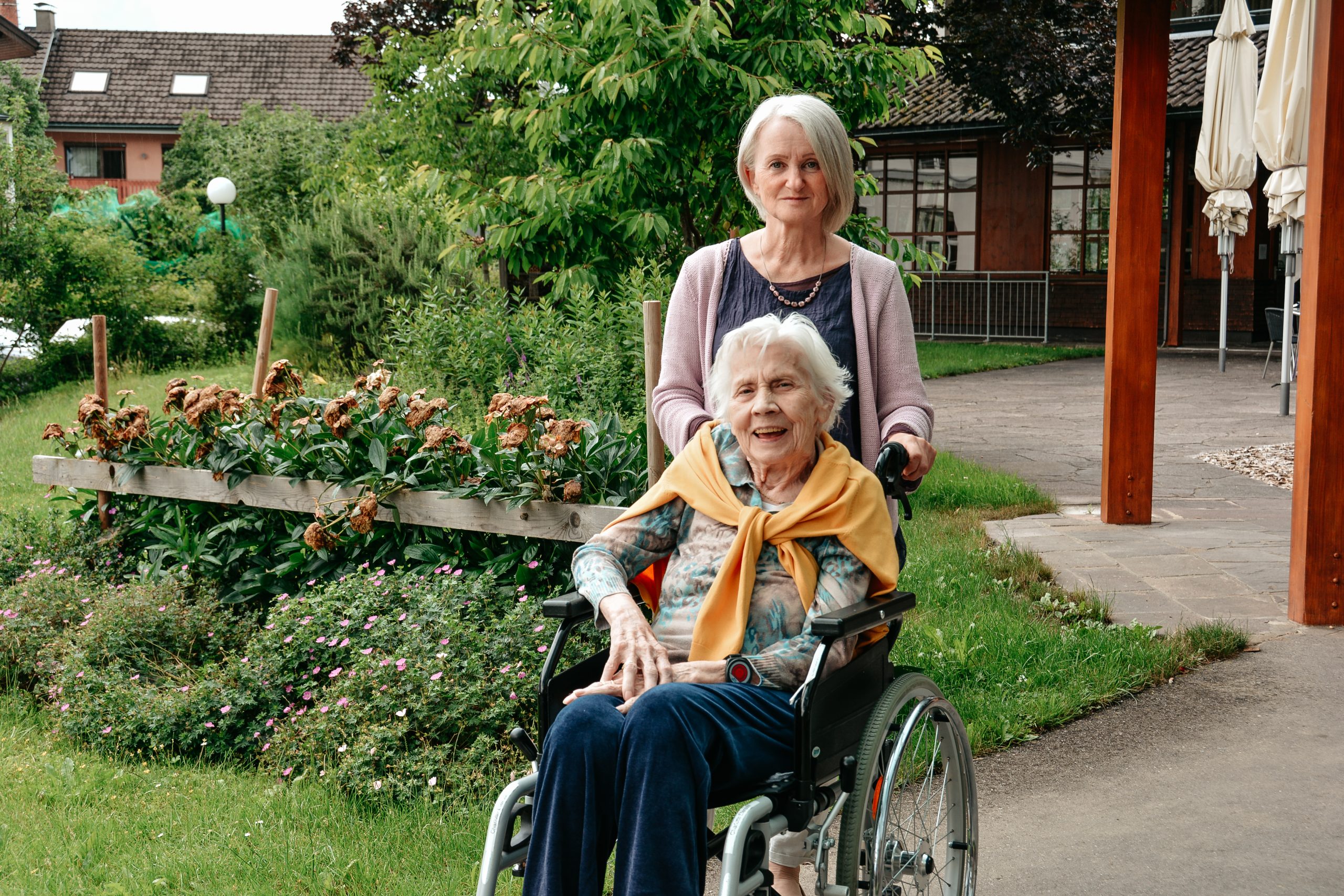 Angelika schiebt Seniorin im Rollstuhl